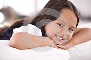 Shes such a cutey. Cropped portrait of a little girl lying on the sofa at home.