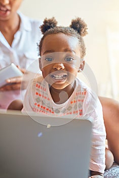 Shes a tech-savvy kid. Cropped portrait of an adorable little girl playing on a laptop at home.