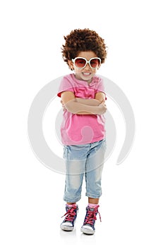 Shes a tiny trendsetter. Studio shot of a cute little girl in casual wear and sunglasses posing against a white