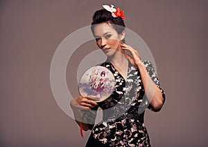 Shes in touch with her roots. Studio shot of an attractive young woman dressed in traditional asian clothing.