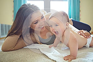 Shes a wriggly little one. a mother and her baby daughter at home.