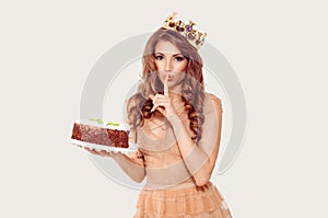 Shh it`s a surprise. Woman holding a cake in her hand and showing silence quiet sign gesture  white background. Girl full