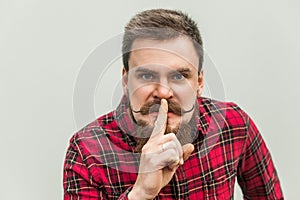 Shh sign. Anger businessman with beard and handlebar mustache
