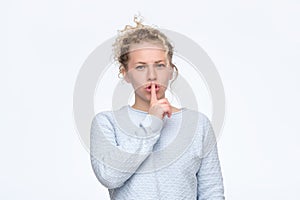 Shh sign. Beautiful curly womashowing silent sign. Studio shot.