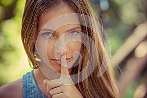 Shh. Woman wide eyed asking for silence secrecy with finger on lips hush hand gesture green park outdoor background Pretty girl