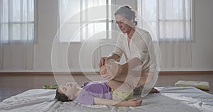 Shiatsu treatment. Masseuse giving treatment to a young girl, using different methods.