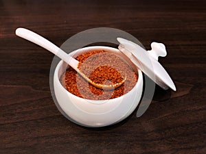 Shichimi togarashi,Cayenne pepper in a white cup, preparing to put in Ramen noodles or gyÅ«don. Popular Japanese seasoning