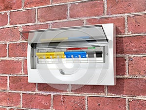 Shield with circuit breakers on a brick wall.