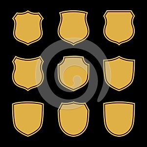 Shield shape gold icons set. Simple flat logo on black background. Symbol of security, protection, safety, strong