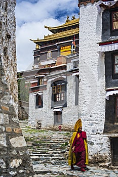 Tibetan Buddhist monk walks in street of Tashilhunpo Monastery . Shigatse , Tibet