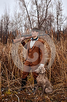 shikari with gray hunting dog in autumn forest. Image taken during big game hunting trip. photo