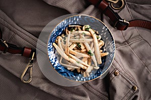 Shimeji mushrooms in a bowl on grey chef`s apron background. Pickled japanese brown beech or buna shimeji. Umami taste