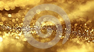 Shimmering gold particles and blurred lights creating festive abstract texture. Golden background. Slow motion.