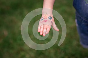 Shimmering sparkling glitter tattoo on a child& x27;s hand at a birthday party