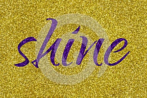 Shine lettering word ultra violet on gold glitter texture. Shiny sparkle background