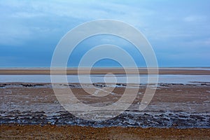 Shingle rocky beach of Norfolk coast and dark blue sky, Northern Sea, Holkham beach, United Kingdom