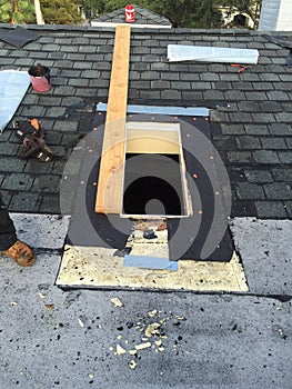 Shingle roof and skylight Repairs in process, roofer, tools