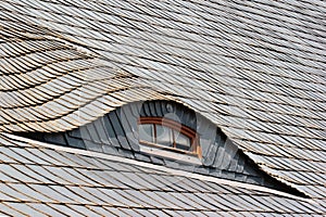 Shingled roof with small eye-like attic window