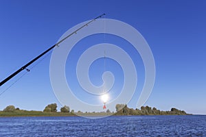 Shining fishing lure on the fishing line against the lake.fishing concept