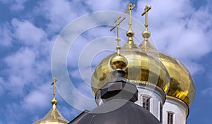 Shining golden cupola of Kremlin in Dmitrov under blue cloudy sky