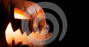 Shining Jack-O-Lantern. Halloween pumpkin with scary face smoke inside with flame isolated on the black background.