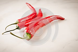 shining red hot pepper/red hot pepper on a white marble background. Selective focus and copyspace