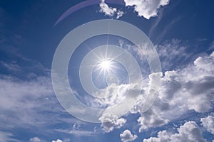 Shining sun on clear blue sky white clouds with lens flare of sunlight on sky background Bright sun on blue sky Concept Nature and