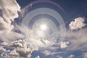 Shining sun on clear blue sky white clouds with lens flare of sunlight on sky background Bright sun on blue sky Concept Nature and