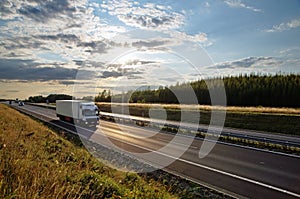 Shining sun over the highway, white truck on the road