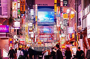 Shinjuku at night vibrant busy street night life with many lightbox signs - Tokyo