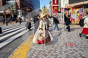 Shinjuku, Tokyo, Japan - December 26, 2018: Beautiful girl with crossplay suit waling in the crowd pedestrians people. Famous