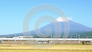 A Shinkansen bullet train passes below Mt. Fuji in Shizuzoka, Japan