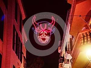 Shinning red mask of devil on black night photo