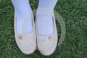 Shinny footwear on the grass. Girl with beautiful shoes. Leather shoes isolated on a grass. Top view of shoe pair.