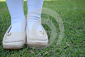 Shinny footwear on the grass. Girl with beautiful shoes. Leather shoes isolated on a grass