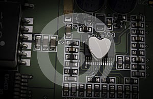 Shinny metal heart attached on an electronic circuit