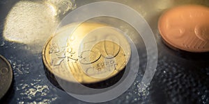 Shiny 50 cents euro coin closeup on a glass table