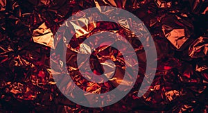 A shiny abstract background featuring a crumpled red metallic foil texture surface