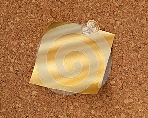 Shiny blank gold sticky note pinned with tack. Golden idea or message concept