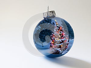 Shiny Blue Holiday Ornament Reflects Brightly Lit Colorful Christmas Tree