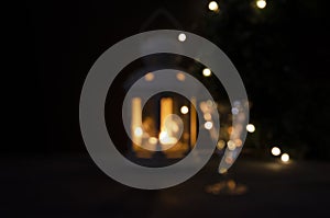 Shiny blurred background for design. Glass with white wine with garland lights and candle lantern blurred. Night picture.