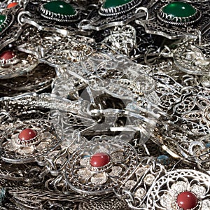 Shiny bunt of silver jewelry with red and green gemstones