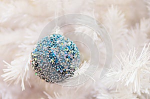 Shiny Christmas ball hanging on a branch White Christmas. Christmas card. Christmas bulb