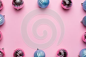 Shiny Christmas blue and pink balls for decoration on pink background with copyspace, new year ball