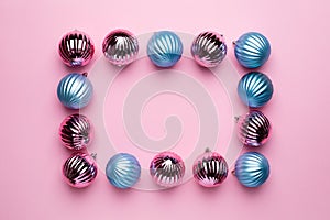 Shiny Christmas blue and pink balls for decoration on pink background with copyspace, new year ball