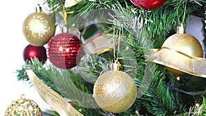 Shiny Christmas tree with blinking lights and putting gold glitter ornament