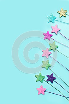 Shiny colored decorative stars on a light blue background