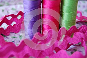 Shiny colorful spools of thread in purple, pink and green