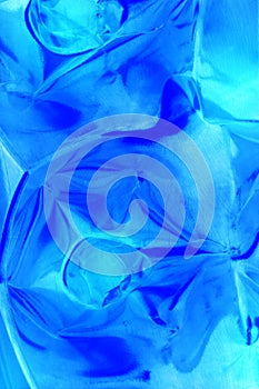 Shiny crinkled plastic background in glowing shades of blue.
