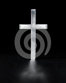 Shiny cross, simple Christian religious symbol, glowing brightly with reflection